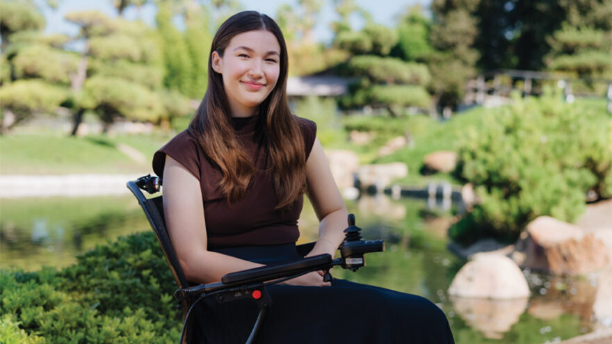 Aubrianna Wilson, Middlebury Class of '23, seated in her wheelchair in a California garden